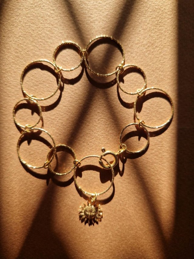 Złota bransoletka z kółek różnej wielkości z zawieszką słońce, strebro 925